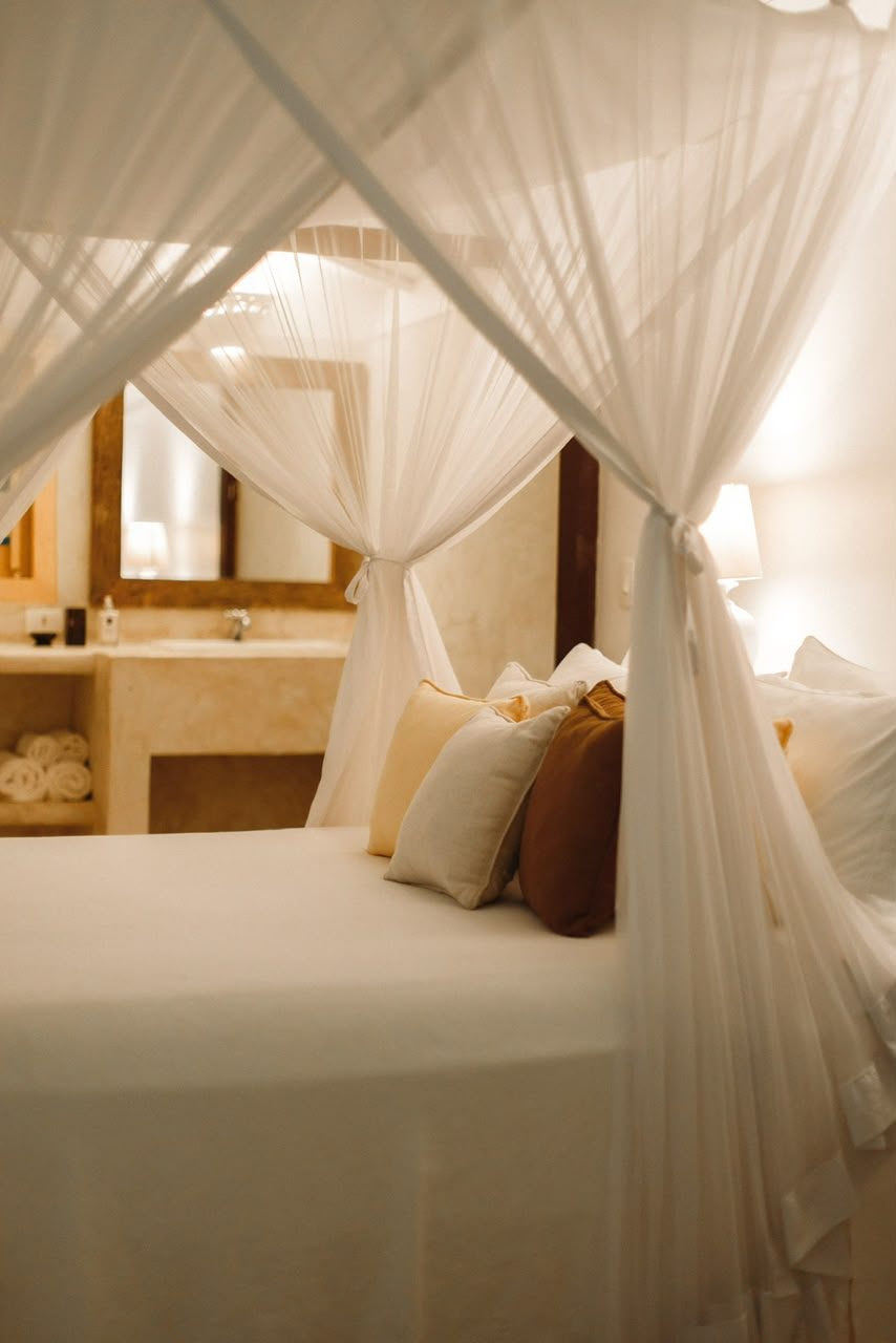 Cama de dossel do Bangalô Amarelo com almofadas em tons de mostarda