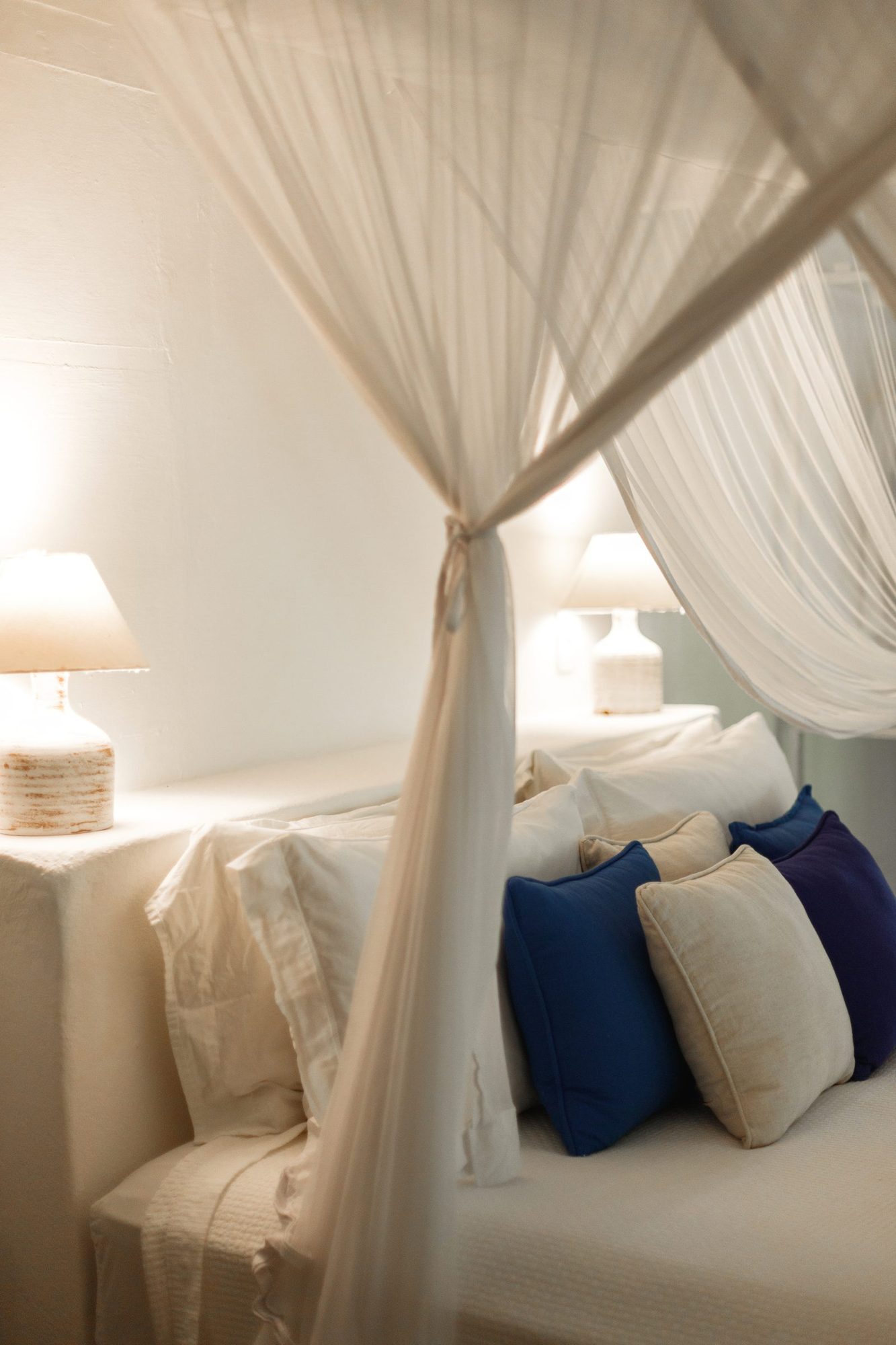 Cama com dossel e almofadas azuis do Bangalô Azul