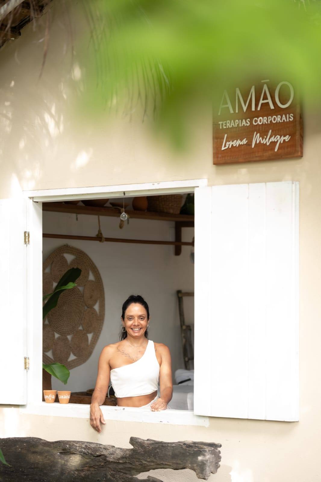Terapeuta Lorena na janela do espaço AMÃO Terapias Corporais