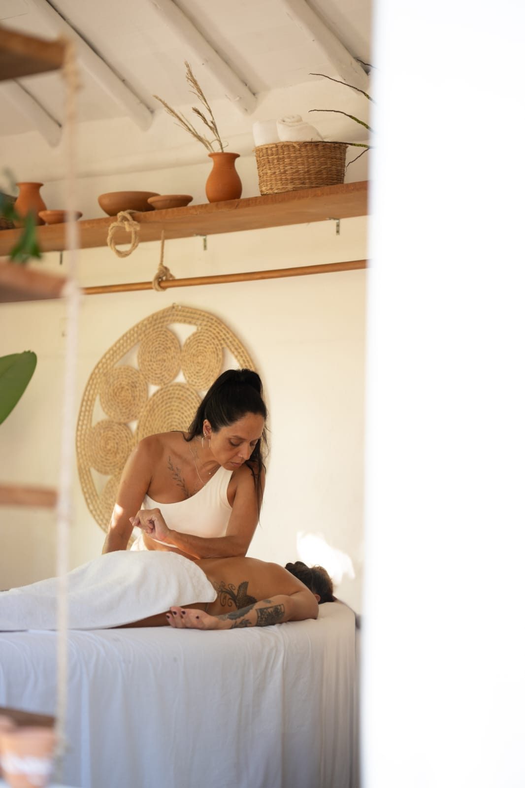 Terapia corporal no espaço AMÃO: massagem com mandala de palha ao fundo